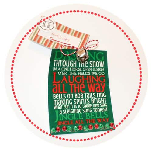 11. Sing Carols tag tied to a silver jingle bell and the Jingle Bells song printed out on paper