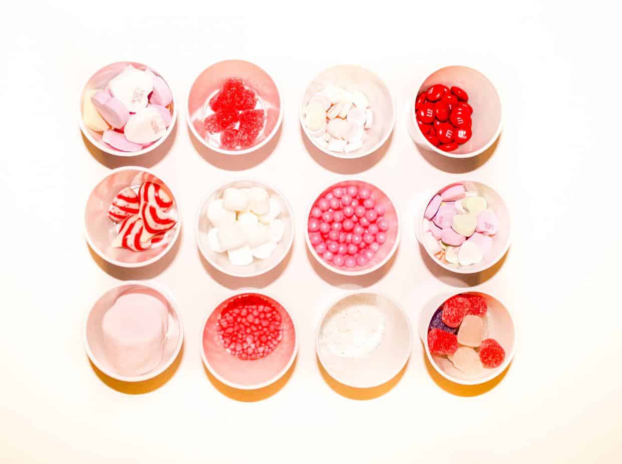 12 small cups filled with various Valentines day candy